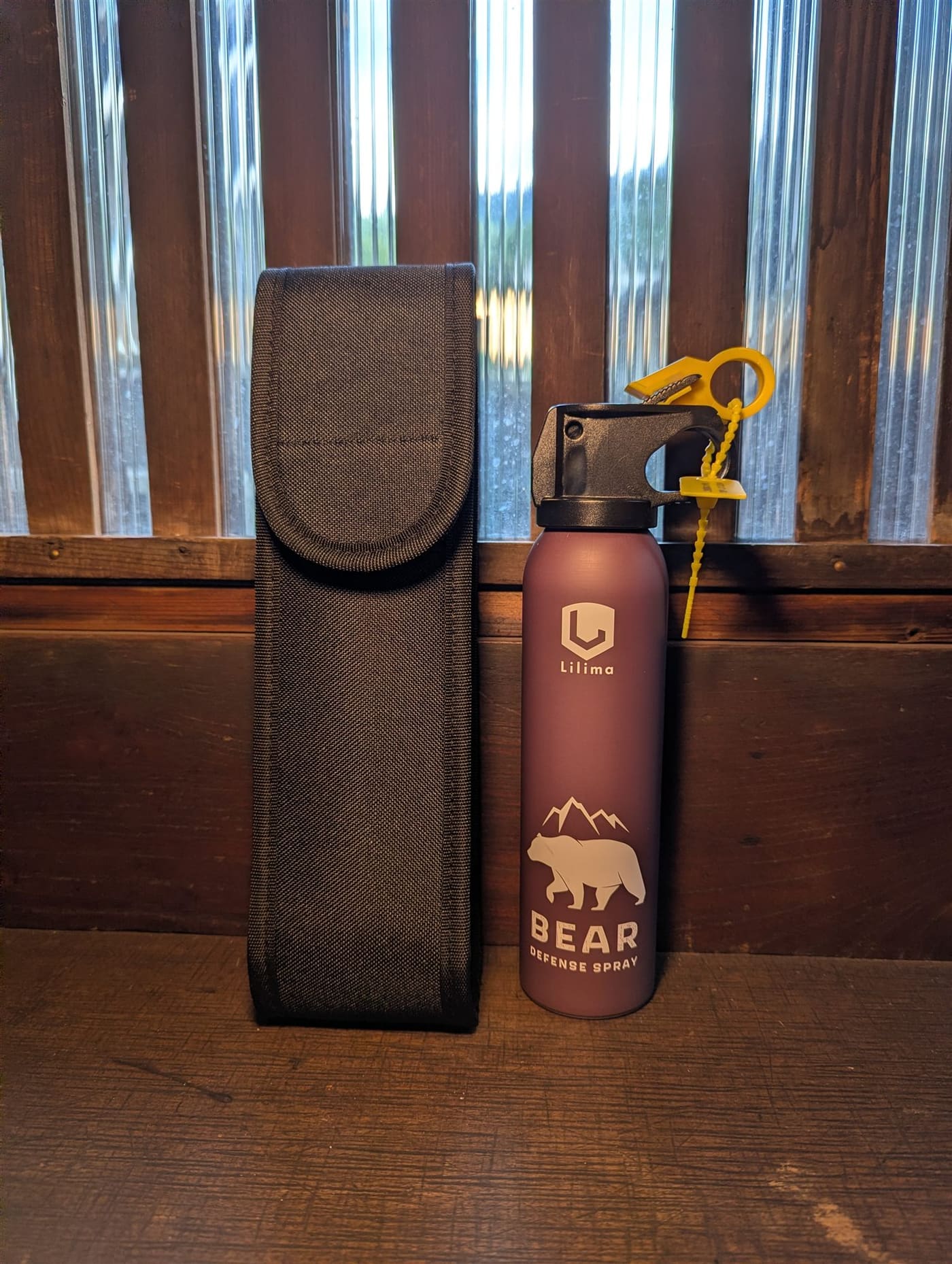 Bear defense spray canister standing next to its black belt holster