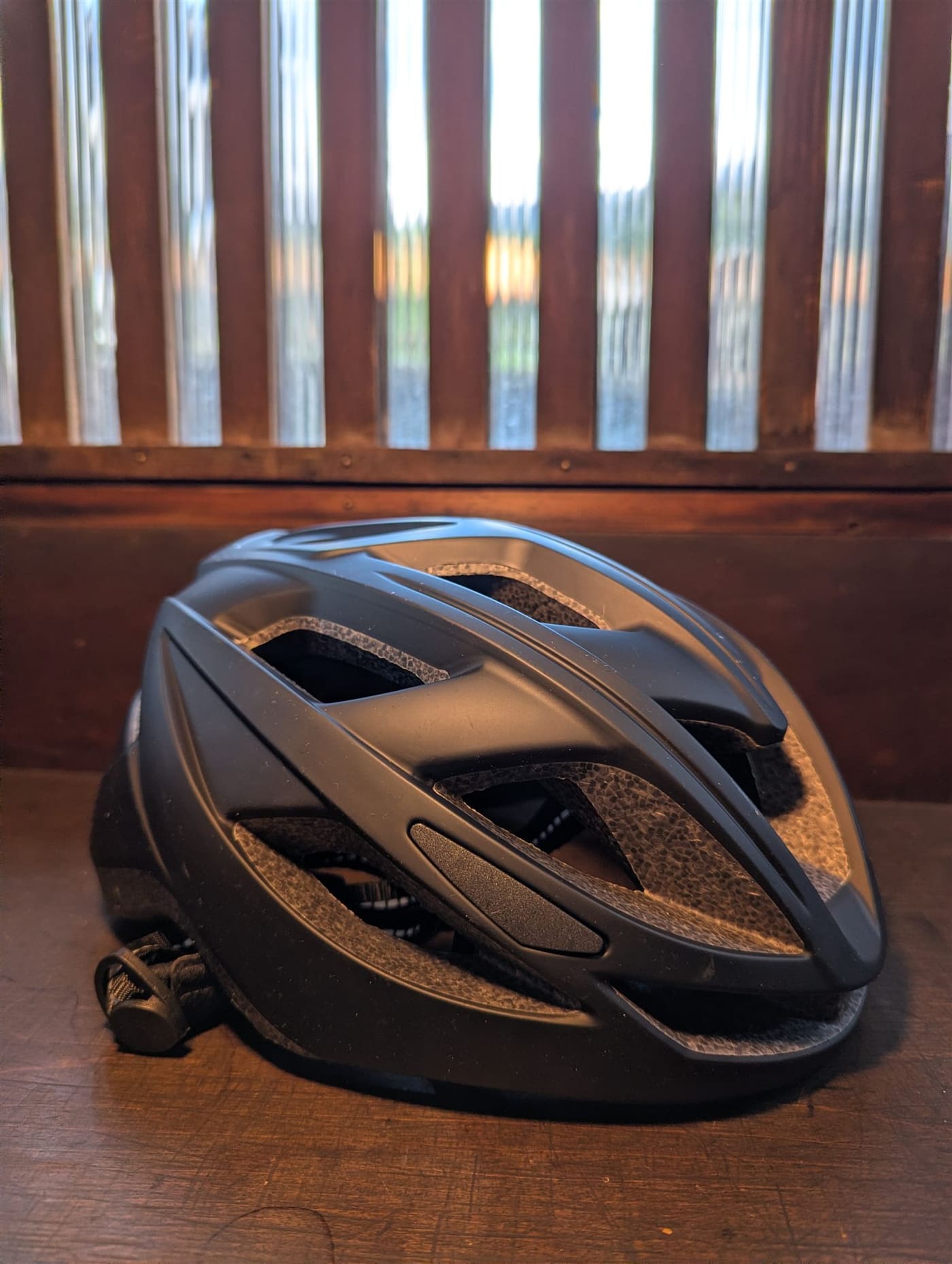 A matte-black cycling helmet on the guesthouse counter, fitted before every ride