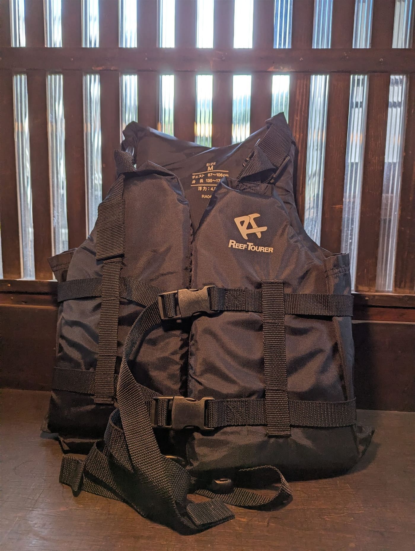 The life jacket — a black buoyancy vest with adjustable buckles