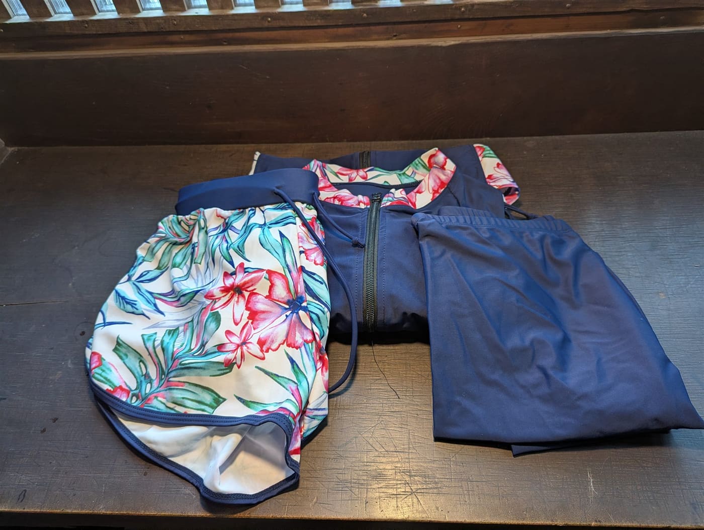 Women's rashguard set — navy zip-up top, leggings and floral swim shorts