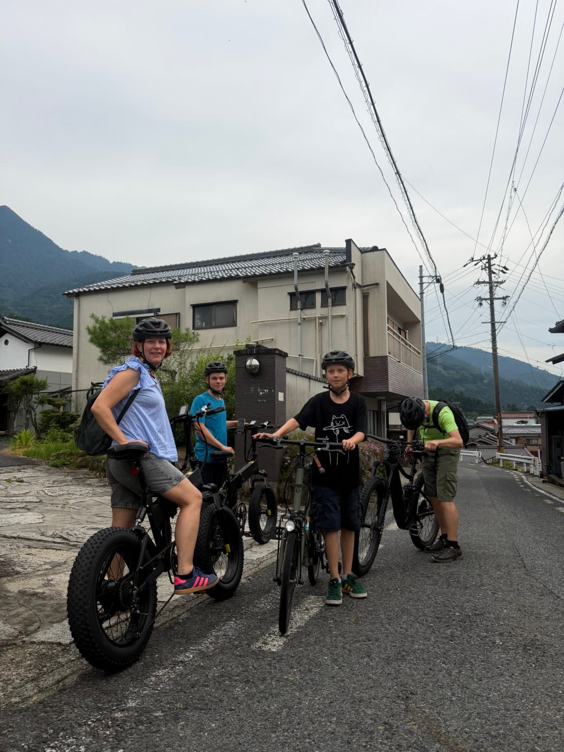 A family of four on fat-tire e-bikes, ready to roll out through the village streets of Nagiso