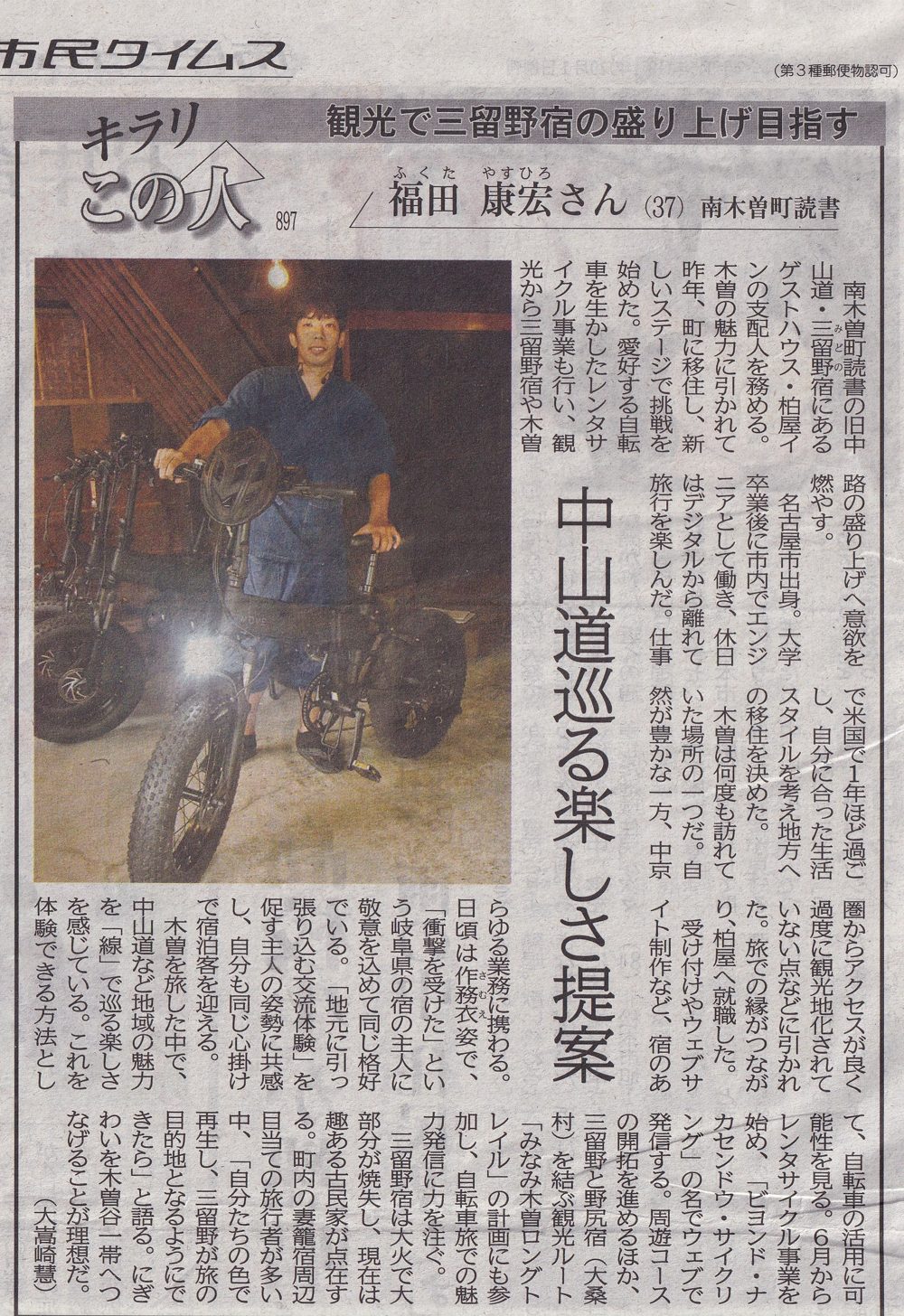 Shimin Times newspaper feature on Yakkun (Yasuhiro Fukuda), standing with an e-bike inside Kashiwaya